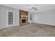 Bright living room with a brick fireplace, soft carpet, and plenty of natural light at 8633 Hilltop Rd, Jonesboro, GA 30236