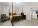 Bedroom featuring a four-poster bed with a green and gold comforter, side table, and an open doorway at 1929 Finnish Ln, Kennesaw, GA 30152