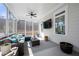 Bright sunroom with a plush sectional sofa, ceiling fan, TV, and ample windows for natural light at 1929 Finnish Ln, Kennesaw, GA 30152
