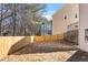 A long, newly fenced back yard backs up to mature trees on a sunny day at 2517 Hampton Park Ct, Marietta, GA 30062