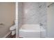 Bathroom featuring tub with white marble-look tile surround at 2628 Miriam Ln, Decatur, GA 30032