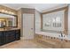 Bright bathroom featuring a soaking tub with decorative tiling and a large black vanity at 2814 Adams Oaks Ln, Marietta, GA 30062