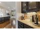 Elegant wet bar area with granite countertop, dark cabinetry, and glass storage at 2814 Adams Oaks Ln, Marietta, GA 30062