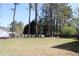 Large backyard with lush trees and a partial view of the fence on a sunny day at 3274 Jodeco Pl, Jonesboro, GA 30236
