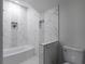 Chic bathroom featuring a tub-shower combo with marble-style tile and built-in shelving at 1882 Rosewood Rd, Decatur, GA 30032