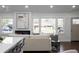 Spacious living room featuring a fireplace, large windows with backyard views, and access to the kitchen at 1882 Rosewood Rd, Decatur, GA 30032