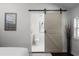 The barn door opens to a luxurious bathroom with marble floors and a modern toilet at 1882 Rosewood Rd, Decatur, GA 30032