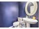 Stylish half bathroom with blue walls, an ornate mirror, and a pedestal sink at 2026 Ellison Nw Way # 13, Kennesaw, GA 30152