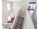 Carpeted staircase featuring white banisters and plenty of natural light from adjacent windows at 2026 Ellison Nw Way # 13, Kennesaw, GA 30152
