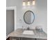 Bathroom featuring granite countertop, dark cabinets, a round mirror and overhead lighting at 3020 Barnes Mill Ct, Roswell, GA 30075