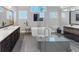 Bright bathroom with double vanities, soaking tub, frameless glass shower and tile flooring at 3020 Barnes Mill Ct, Roswell, GA 30075
