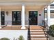 Close-up of the beautiful front porch with columns, brick steps and black railings, and double doors at 3020 Barnes Mill Ct, Roswell, GA 30075