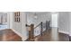 Hallway with dark hardwood flooring, wood railings and white trim on the doors and baseboards at 3020 Barnes Mill Ct, Roswell, GA 30075