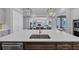 Kitchen island with white countertop, sink and stainless steel dishwasher overlooking the great room at 3020 Barnes Mill Ct, Roswell, GA 30075