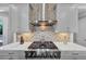 Close-up of the kitchen range and hood, featuring stainless steel appliances and a decorative tile backsplash at 3020 Barnes Mill Ct, Roswell, GA 30075