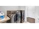 Modern laundry room with front load washer and dryer and white storage shelf at 3020 Barnes Mill Ct, Roswell, GA 30075