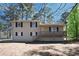 Charming split-level home featuring a welcoming front porch and neutral siding with black shutters at 4130 N Quail Dr, Douglasville, GA 30135