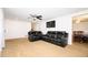 Open-concept living area with plush carpet, and comfortable leather furniture, leading into the dining room at 4130 N Quail Dr, Douglasville, GA 30135