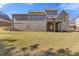 Expansive backyard featuring a deck, lush green lawn, and a home with large windows for ample natural light at 5977 Wildcreek Rd, Sugar Hill, GA 30518