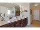 Bathroom featuring double sinks, granite countertops and dark wood cabinets at 5977 Wildcreek Rd, Sugar Hill, GA 30518