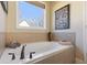 Corner bathtub with tile surround and classic fixtures at 5977 Wildcreek Rd, Sugar Hill, GA 30518