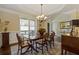 Dining room featuring natural light, wainscoting, and a chandelier at 5977 Wildcreek Rd, Sugar Hill, GA 30518