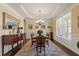 Formal dining room with a tray ceiling, chandelier, and wainscoting at 5977 Wildcreek Rd, Sugar Hill, GA 30518