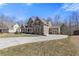 A house with a large driveway and three car garage on a partly cloudy day at 5977 Wildcreek Rd, Sugar Hill, GA 30518