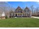 Charming two-story home featuring a well-manicured lawn and inviting front porch at 5977 Wildcreek Rd, Sugar Hill, GA 30518