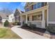 Charming front porch of home with gray siding and brick columns at 5977 Wildcreek Rd, Sugar Hill, GA 30518