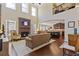Open-concept living room with stone fireplace, hardwood floors, and access to kitchen at 5977 Wildcreek Rd, Sugar Hill, GA 30518