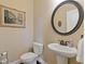 Charming powder room featuring a pedestal sink and decorative mirror at 5977 Wildcreek Rd, Sugar Hill, GA 30518