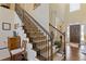 Elegant staircase with carpet runner, wood railing, and view of the front entrance at 5977 Wildcreek Rd, Sugar Hill, GA 30518