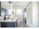 Bathroom features a blue vanity, patterned floor, white walls, and a shower with a blue and white patterned curtain at 1893 Windsor Sw Dr, Atlanta, GA 30311