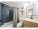 Updated bathroom with blue tile shower, white vanity, and modern fixtures at 1893 Windsor Sw Dr, Atlanta, GA 30311