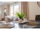 Well-lit dining area showcases decorative placemats, plants, and vases, complemented by a nearby living room with a view at 1893 Windsor Sw Dr, Atlanta, GA 30311