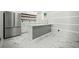 Finished basement featuring a stylish bar area with modern cabinetry, stainless steel refrigerator, and marbled floors at 681 Fielding Sw Ln, Atlanta, GA 30311