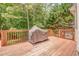 A wooden deck featuring a large grill and views of mature trees and the yard at 119 Creekside Vw, Hiram, GA 30141