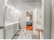 Bright main bathroom featuring double sinks, decorative cabinets, and an entrance to the main bedroom at 119 Creekside Vw, Hiram, GA 30141