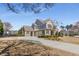 Spacious home boasts a long driveway, three-car garage, and inviting front porch with stone accents at 2564 Lulworth Ne Ln, Marietta, GA 30062
