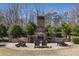 Outdoor fireplace with seating is surrounded by a brick patio and landscaping at 2564 Lulworth Ne Ln, Marietta, GA 30062