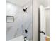 Modern bathroom featuring marble style tiling, black matte fixtures, and an open doorway at 3524 Brookfield Ln, Decatur, GA 30032