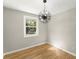 A bright bedroom with wood floors, a modern light fixture, and a backyard view at 3524 Brookfield Ln, Decatur, GA 30032