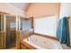 Bright bathroom featuring a tiled shower, soaking tub, and a window for natural light at 103 Gold Springs Ct, Canton, GA 30114