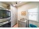 Well-lit laundry room featuring a granite countertop, sink, modern washer/dryer and storage cabinets at 103 Gold Springs Ct, Canton, GA 30114