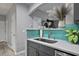 Close-up of the kitchen sink area with blue tile backsplash and gray cabinets at 21 Samuel Nw Way, Cartersville, GA 30121