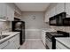 Traditional kitchen design with white cabinetry and black appliances at 5159 Roswell Rd # 7, Sandy Springs, GA 30342