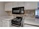 Traditional kitchen design featuring white cabinets, tile backsplash, and black microwave at 5159 Roswell Rd # 7, Sandy Springs, GA 30342