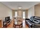 Open living room area featuring hardwood floors, dining table, and a comfortable black leather sofa at 5159 Roswell Rd # 7, Sandy Springs, GA 30342