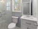 Modern bathroom with a tiled shower, a white vanity with carrara top and a large window at 3170 Old Hwy 92 Dr, Acworth, GA 30102